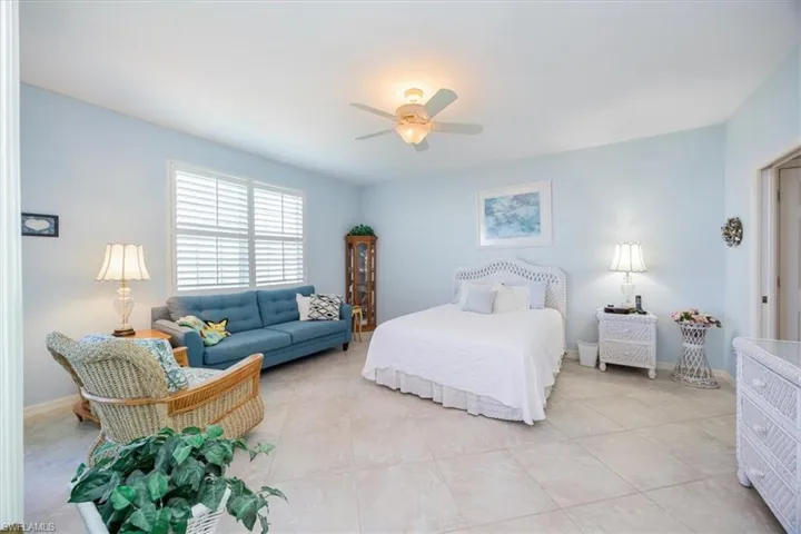 Bedroom with ceiling fan and light tile patterned floors
