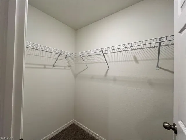 Walk in closet featuring dark carpet