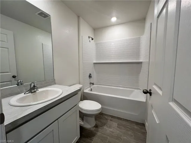 Full bathroom featuring shower / washtub combination, vanity, and wood tiled floors