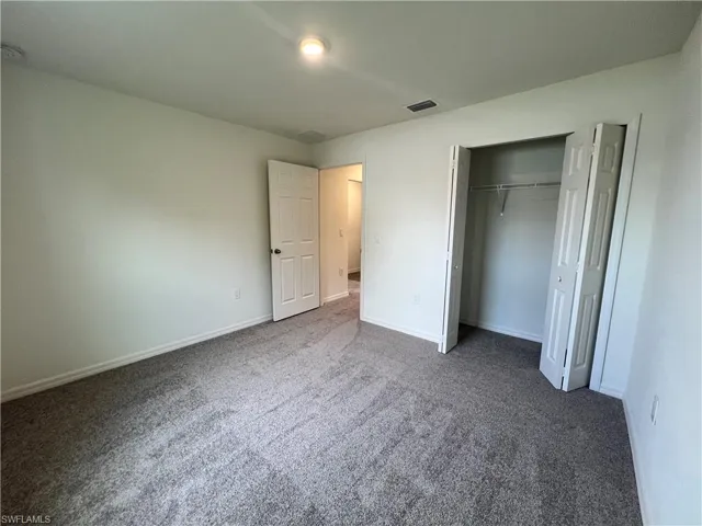 Unfurnished bedroom featuring carpet floors and a closet