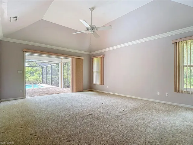 Master bedroom  featuring a vaulted ceiling, crown molding, and pocket sliders that open up to the screened-in lanai