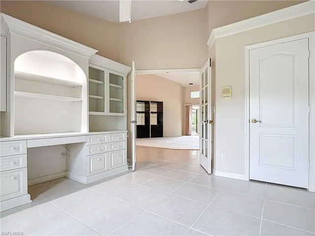 Den with French doors, a large desk, and a closet