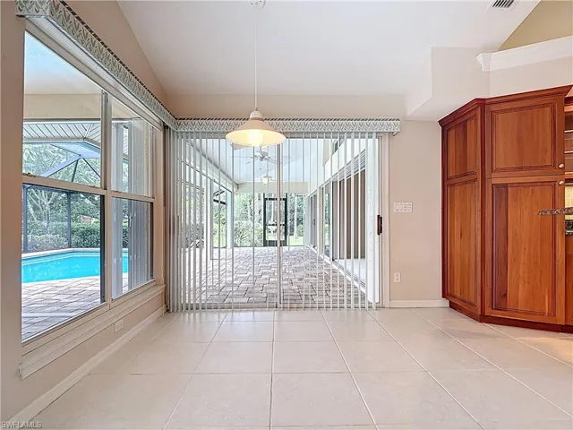 Unfurnished dining area with vaulted ceiling and light tile patterned floors