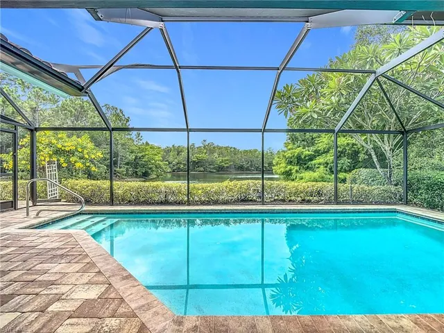 Swimming pool featuring a ceiling fan, skylight windows, a patio area, a lanai, water and preserve view