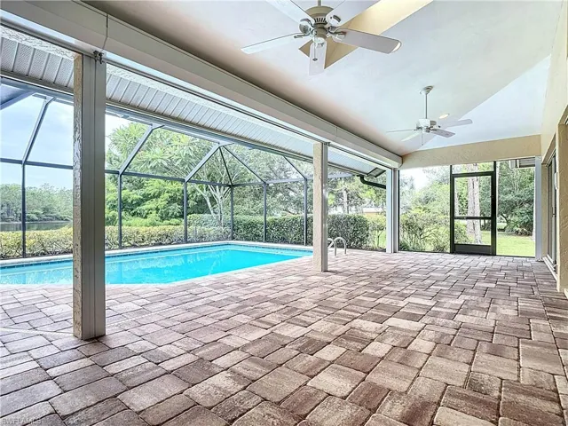 Swimming pool featuring a ceiling fan, skylight windows, a patio area, a lanai, water and preserve view