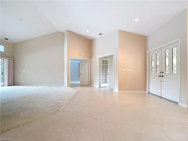 Foyer opening up to Master Bedroom, Den, and Living Room with vaulted ceiling and large pocket sliders.