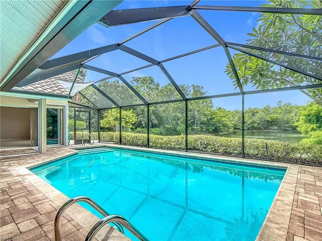 Swimming pool featuring a ceiling fan, skylight windows, a patio area, a lanai, water and preserve view