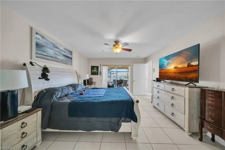 Bedroom with access to exterior, light tile patterned floors, and ceiling fan
