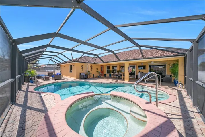 Integrated pool / hot tub with a sunroom, a patio, and a lanai
