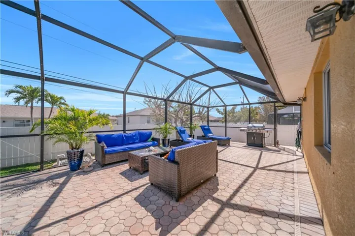 Fenced backyard with a sunroom, a patio, a lanai, an outdoor lounge area, and grilling area