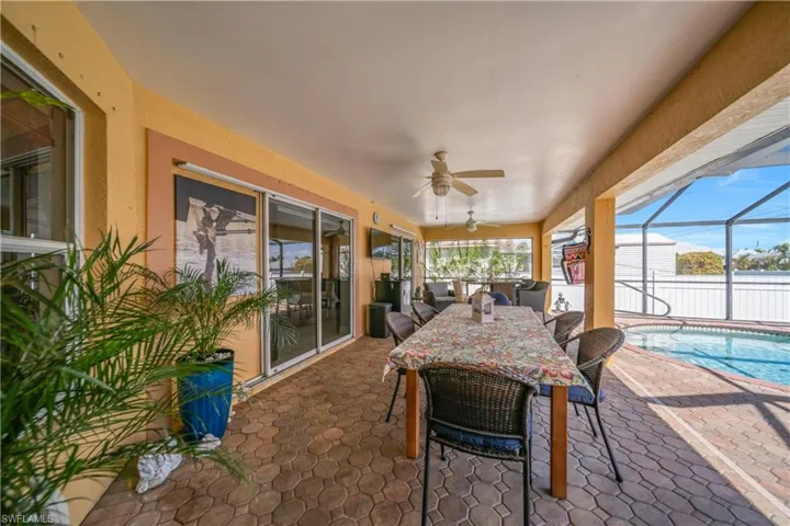 Sunroom / solarium featuring a ceiling fan, outdoor dining area, and a patio area