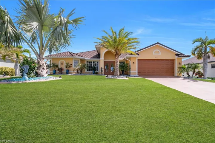 View of front facade featuring stucco siding, an attached garage, concrete driveway, and a front yard