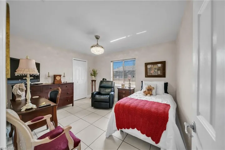 Bedroom featuring light tile patterned floors and a closet