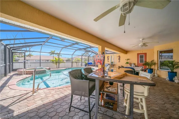 View of pool featuring a sunroom, patio surround, a lanai, and outdoor dining space