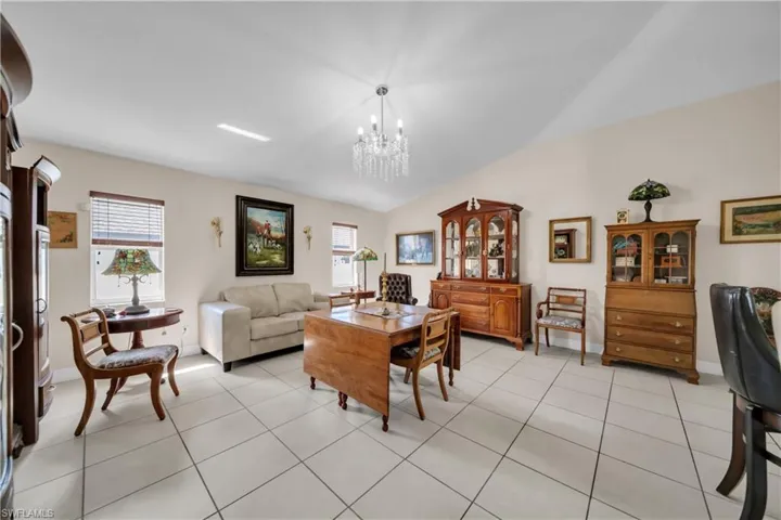 Dining area featuring vaulted ceiling, suspended lighting, and light tile patterned floors