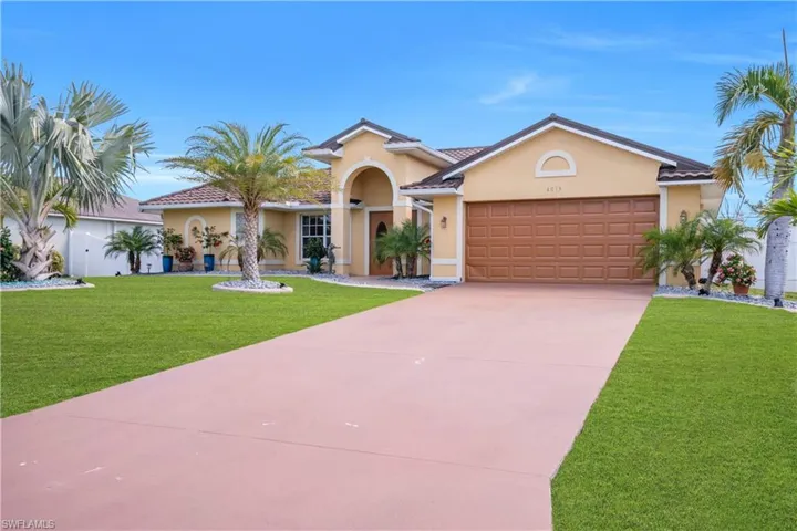 Mediterranean / spanish home with a front lawn, an attached garage, stucco siding, driveway, and a tile roof