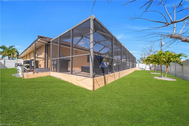 Back of property featuring a sunroom, a fenced backyard, and glass enclosure