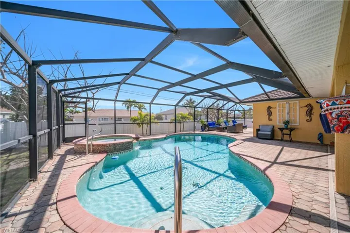 Combined pool / hot tub with a sunroom, a patio, and glass enclosure