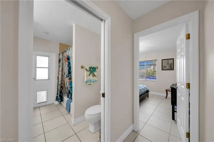 Ensuite bathroom featuring light tile patterned floors, plenty of natural light, and shower / bathtub combination with curtain