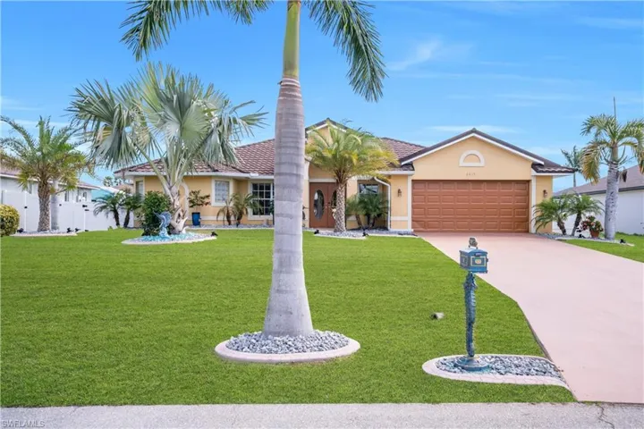 View of front of home featuring stucco siding, an attached garage, a front lawn, and concrete driveway