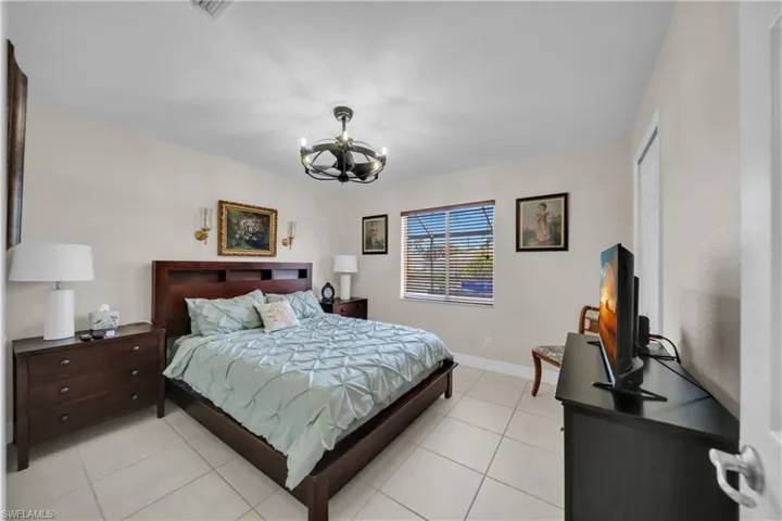 Bedroom with suspended lighting and light tile patterned flooring