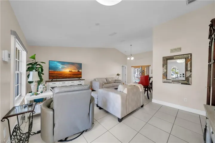 Living area featuring vaulted ceiling and light tile patterned flooring
