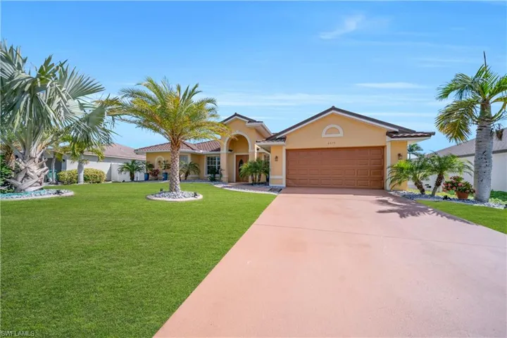 View of front of property featuring an attached garage, a front lawn, stucco siding, and concrete driveway