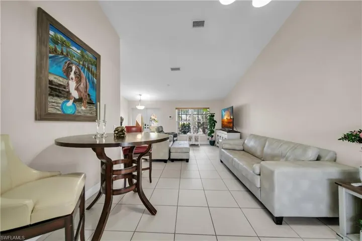 Living room with light tile patterned floors and lofted ceiling