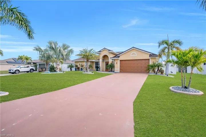 View of front of house featuring a front yard, stucco siding, driveway, and an attached garage