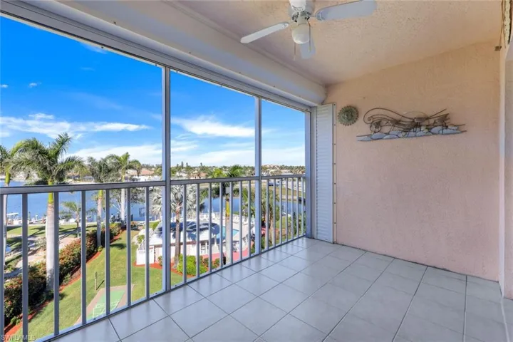 Unfurnished sunroom featuring ceiling fan and a water view