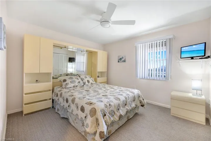 Bedroom with light colored carpet and ceiling fan