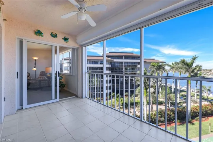 Unfurnished sunroom with ceiling fan and a water view