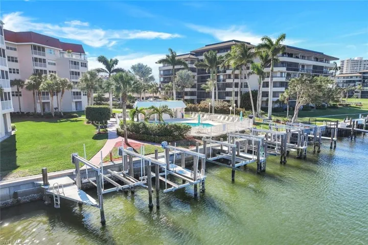 View of dock featuring a community pool, a water view, and a lawn