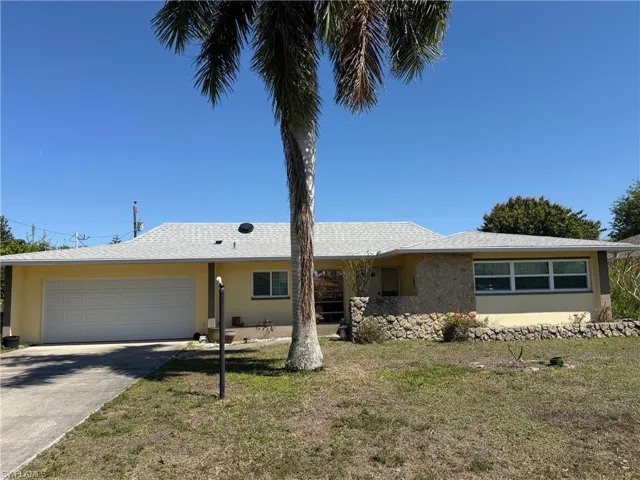 Single story home with an attached garage, stucco siding, a front yard, and concrete driveway