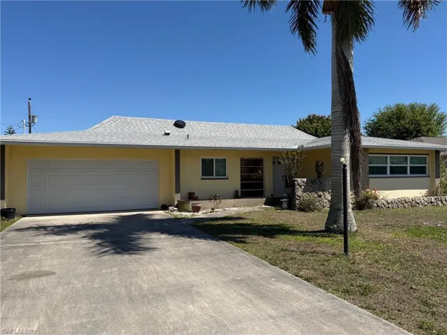 Ranch-style house featuring stucco siding, an attached garage, driveway, a front lawn, and roof with shingles