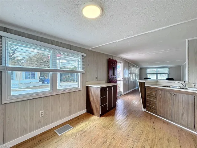 Kitchen with visible vents, light countertops, light wood-type flooring, a wealth of natural light, and a sink