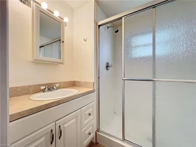 Full bath featuring a shower stall and vanity