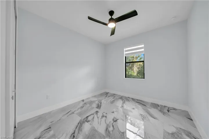 Bedroom with ceiling fan, a closet, and marble finish flooring