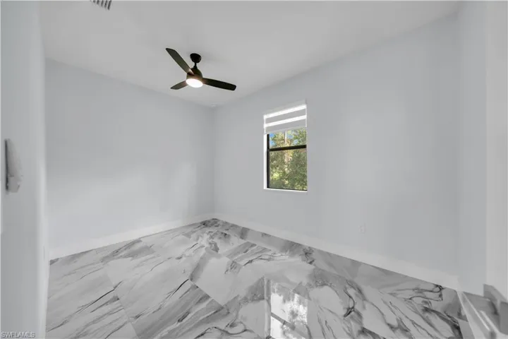 Spacious Den with marble finish floors and a ceiling fan