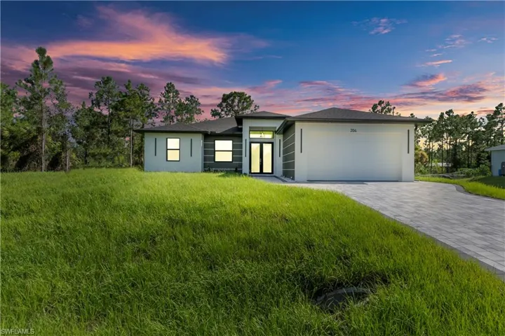 View of front facade featuring stucco siding, an attached garage