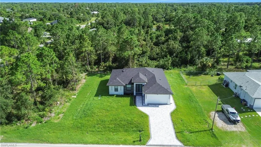 Aerial view of property and surrounding area featuring a heavily wooded area