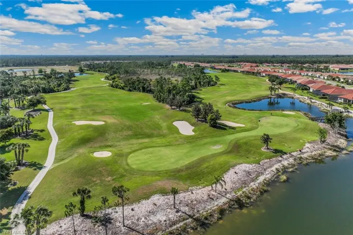 Aerial view of residential area with a golf course and a large body of water