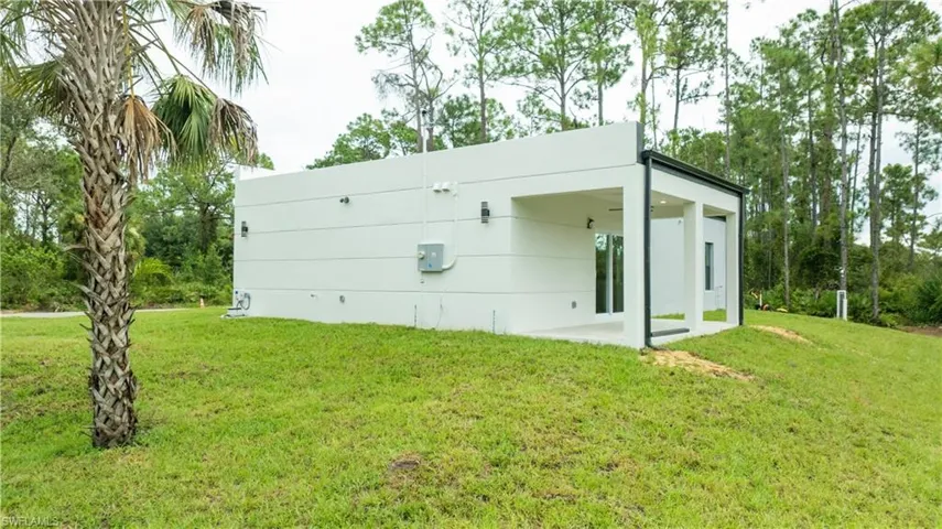 Back of property featuring a lawn and a patio