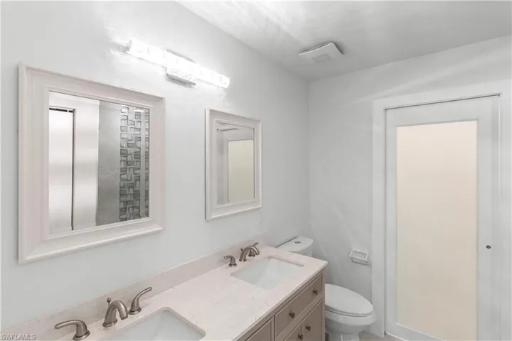 Bathroom featuring double vanity and toilet