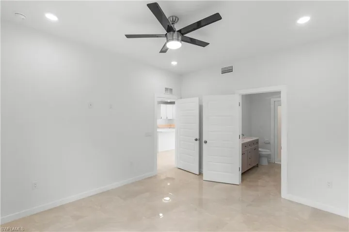 Unfurnished bedroom with recessed lighting, ensuite bathroom, and ceiling fan
