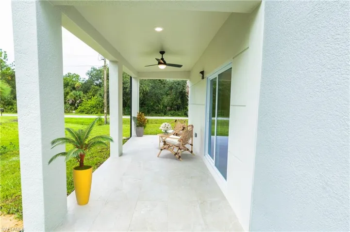 Porch featuring a ceiling fan and a lawn