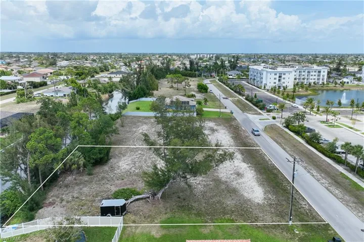 Aerial view of property and surrounding area with property boundaries highlighted and a nearby body of water