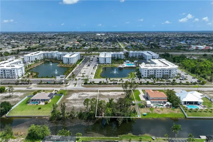 Drone / aerial view of a nearby body of water and apartment complex