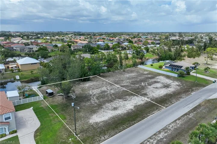 Aerial perspective of suburban area featuring a nearby body of water