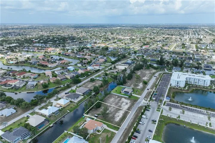 Aerial view of property's location with nearby suburban area and a nearby body of water